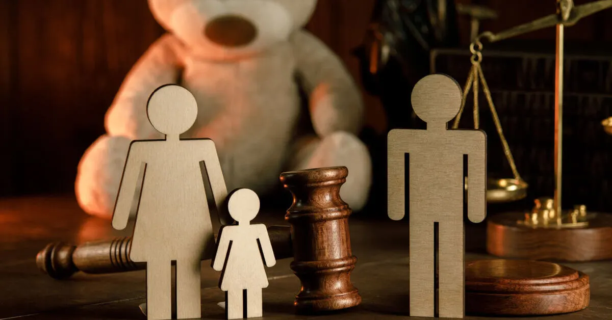 Figuras de familia en madera y un mazo judicial representan el cuidado y custodia en Panamá y el bienestar del menor tras la separación